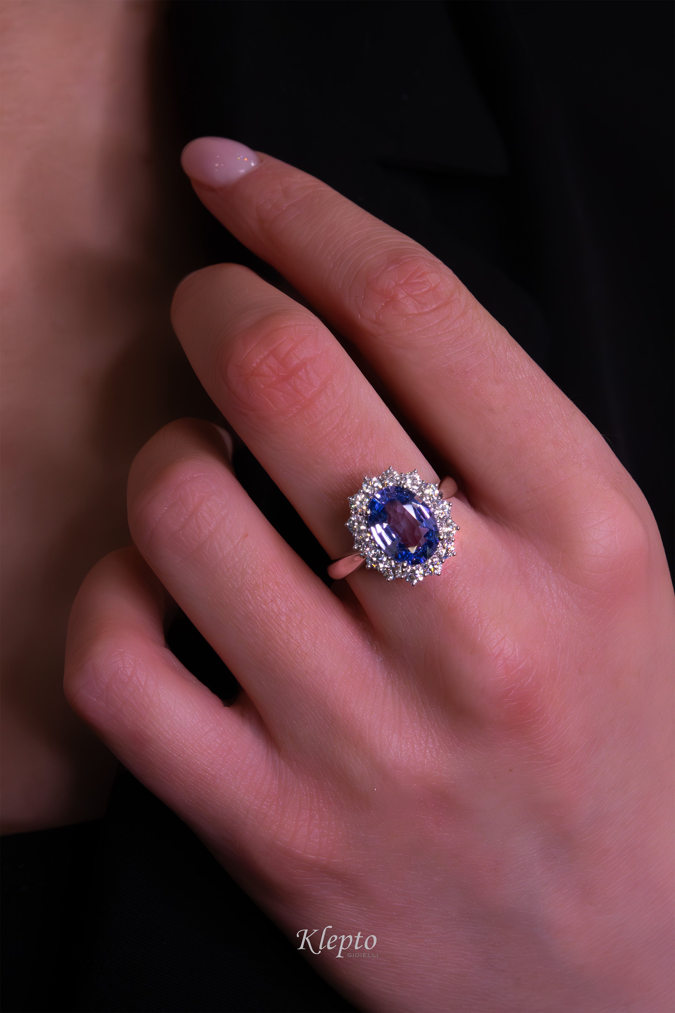 Classic white gold ring with blue sapphire and diamond surround