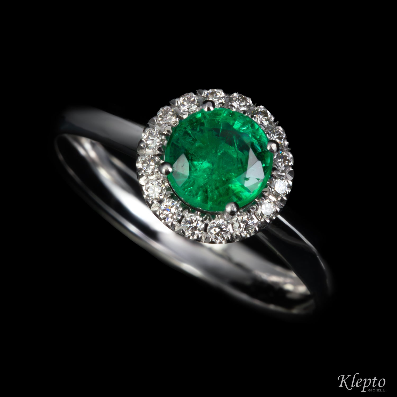 Classic white gold ring with Emerald and diamond surround