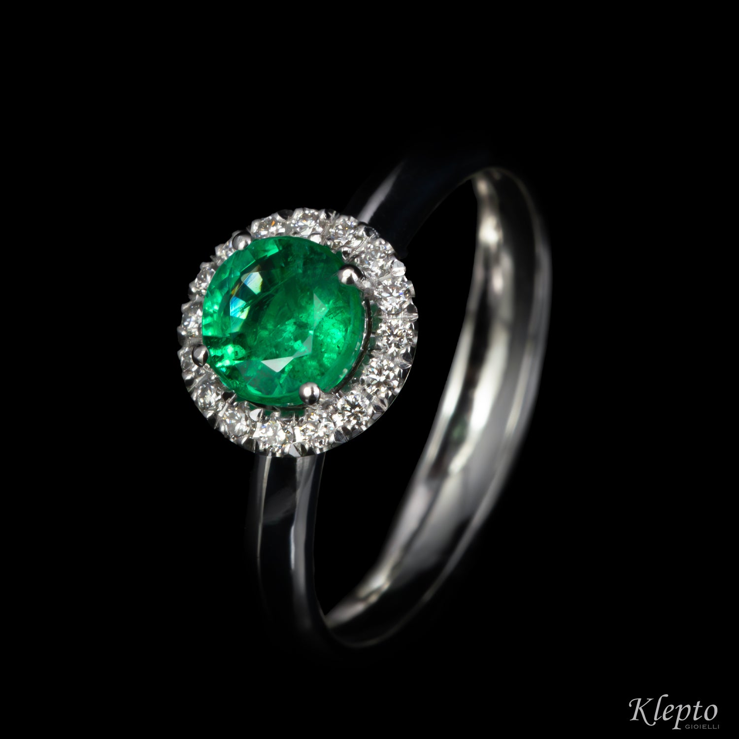 Classic white gold ring with Emerald and diamond surround